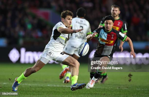 Antoine Dupont of Toulouse kicks the ball past Marcus Smith during the Investec Champions Cup match between Harlequins and Stade Toulousain at...