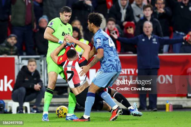 Emiliano Martinez and Boubacar Kamara of Aston Villa clash with Neal Maupay of Brentford during the Premier League match between Brentford FC and...