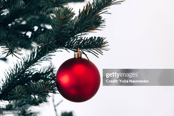 a christmas bauble hangs from a tree. - lametta stock-fotos und bilder