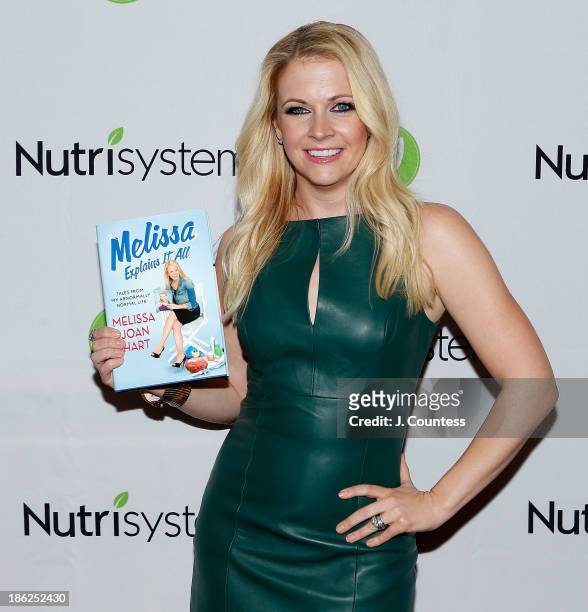 Actress/author Melissa Joan Hart poses for a photo witha copy of her new book "Melissa Explains It All: Tales from My Abnormally Normal Life" at the...
