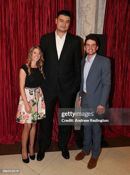 Yao Ming, Former Chinese basketball player, poses for a photograph next to Keegan Bradley and his girlfriend Jillian Stacey at the Welcome Reception...