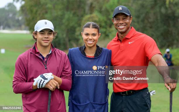 Tiger Woods of The United States poses for a picture on the first tee with his son Charlie Woods and his daughter Sam Woods who was caddying for...