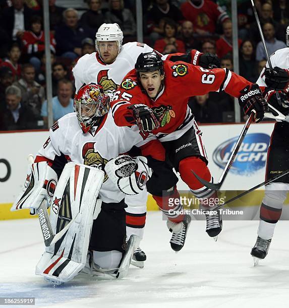 Chicago Blackhawks' Andrew Shaw is checked into Ottawa Senators' Craig Anderson during 1st-period action at the United Center in Chicago, Illinois,...