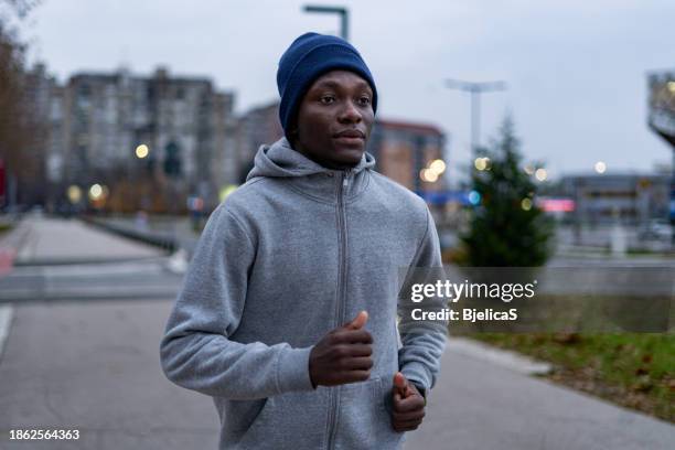 young man jogging in city at dawn - bjelica stock pictures, royalty-free photos & images