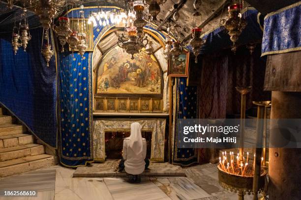 Nun prays in the grotto believed to be the spot where Jesus was born at the Church of the Nativity on December 17, 2023 in Bethlehem, West Bank. Last...