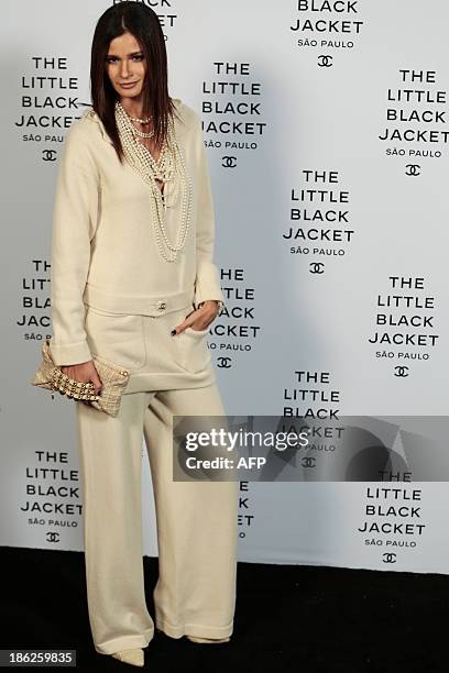 Carol Ribeiro poses as she arrives for the opening ceremony of the Little Black Jacket exhibition of Chanel in Sao Paulo, Brazil, October 29, 2013....