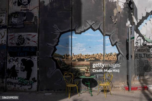 Chairs stand next to graffiti on part of the separation wall on December 17, 2023 in Bethlehem, West Bank. Last month, Christian Palestinian leaders...