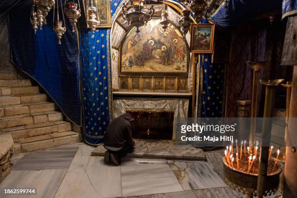 Worshipper prays in the grotto, believed to be the spot where Jesus was born, at the Church of Nativity on December 17, 2023 in Bethlehem, West Bank....