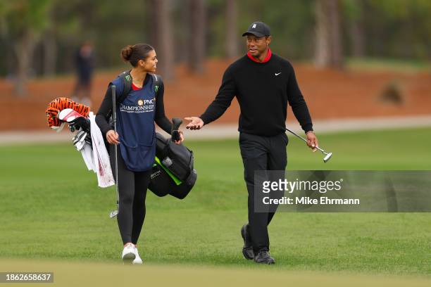 Tiger Woods of the United States and daughter and caddie, Sam Woods, walk on the fifth hole during the final round of the PNC Championship at The...