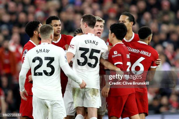 Luke Shaw of Manchester United clashes with Liverpool players during the Premier League match between Liverpool FC and Manchester United at Anfield...