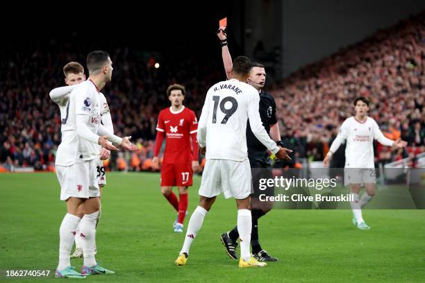 Referee Michael Oliver shows a red card to Diogo Dalot of Manchester United after dissent during the Premier League match between Liverpool FC and...