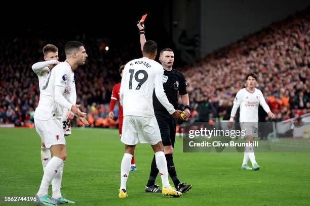 Referee Michael Oliver shows a red card to Diogo Dalot of Manchester United after dissent during the Premier League match between Liverpool FC and...