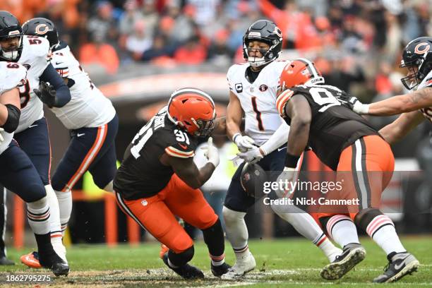 Alex Wright of the Cleveland Browns forces a fumble from Justin Fields of the Chicago Bears during the first quarter at Cleveland Browns Stadium on...