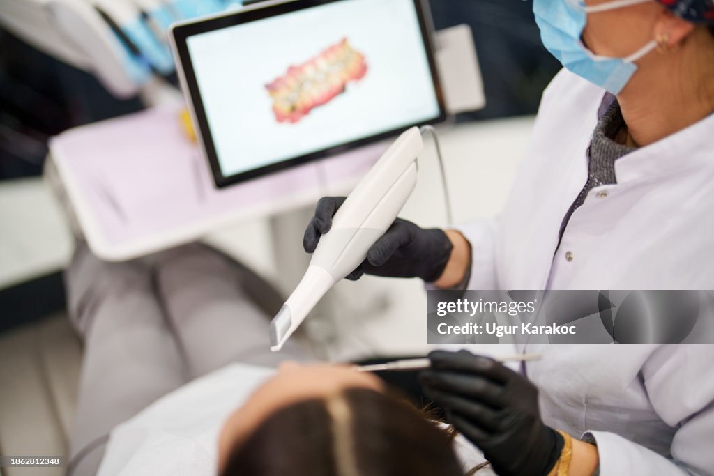 Dentist using a dental scanner for patients teeth