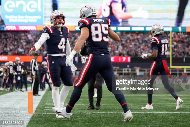 Bailey Zappe and Hunter Henry of the New England Patriots celebrate after Henry's receiving touchdown during the second quarter against the Kansas...