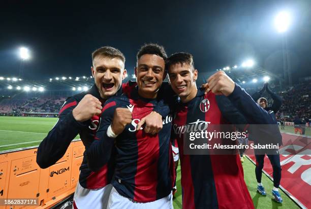 Stefan Posch, Dan Ndoye and Nikola Moro of Bologna FC celebrate following the team's victory in the Serie A TIM match between Bologna FC and AS Roma...