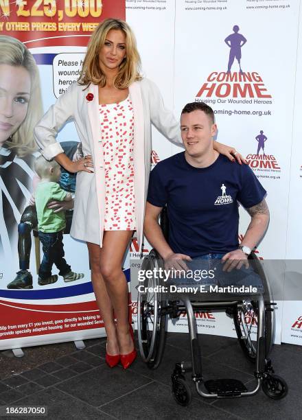 Sarah Harding and Private Michael Swain attend a photocall to launch the Coming Home lottery ticket at Hippodrome Casino on October 30, 2013 in...