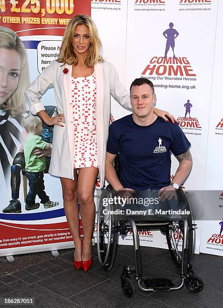 Sarah Harding and Private Michael Swain attend a photocall to launch the Coming Home lottery ticket at Hippodrome Casino on October 30, 2013 in...