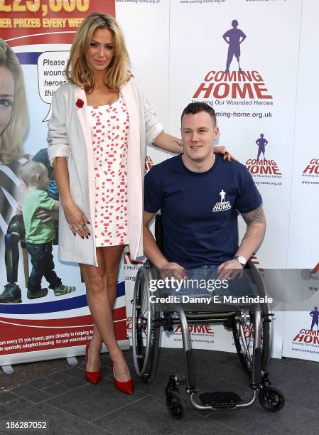 Sarah Harding and Private Michael Swain attend a photocall to launch the Coming Home lottery ticket at Hippodrome Casino on October 30, 2013 in...