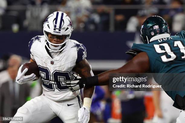 Tony Pollard of the Dallas Cowboys runs the ball as Fletcher Cox of the Philadelphia Eagles defends at AT&T Stadium on December 10, 2023 in...