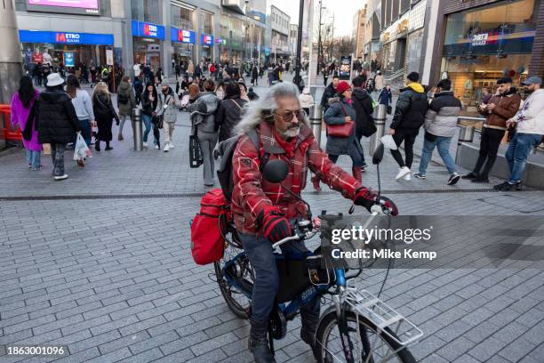 Man rides a midified electric bike through the city centre Bullring area on 14th December 2023 in Birmingham, United Kingdom.