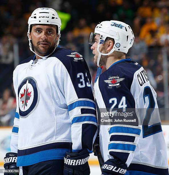 Dustin Byfuglien and Grant Clitsome of the Winnipeg Jets talk during a pause in play against the Nashville Predators at Bridgestone Arena on October...