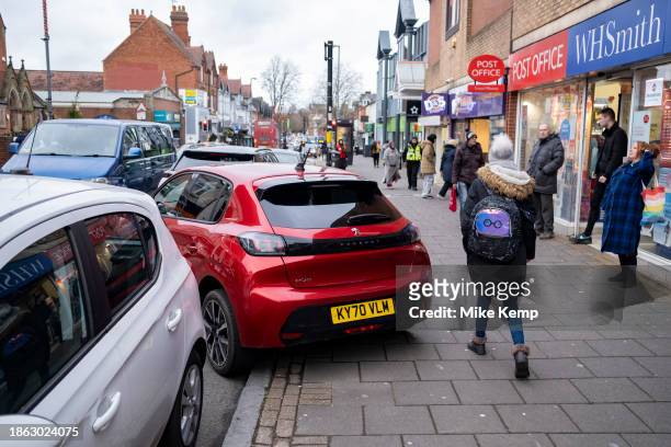 Car parked blocking the pavement on Kings Heath High Street on 20th December 2023 in Birmingham, United Kingdom. Birmingham has become a city where...