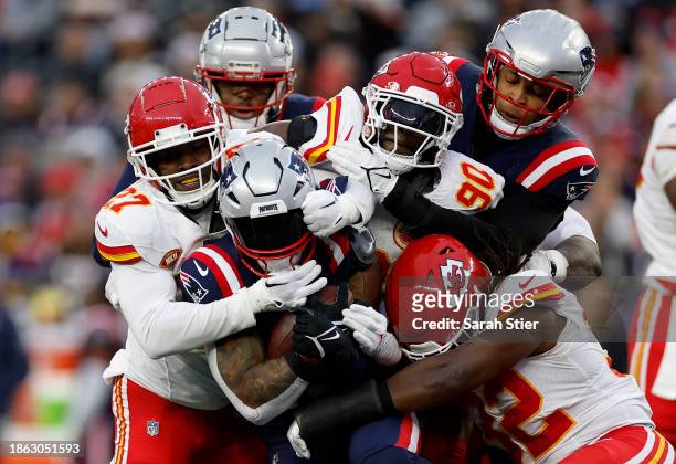 Chamarri Conner, Charles Omenihu, and Nick Bolton all of the Kansas City Chiefs tackle Ezekiel Elliott of the New England Patriots during the fourth...