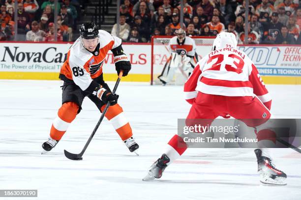 Cam Atkinson of the Philadelphia Flyers skates with the puck by Lucas Raymond of the Detroit Red Wings at the Wells Fargo Center on December 16, 2023...