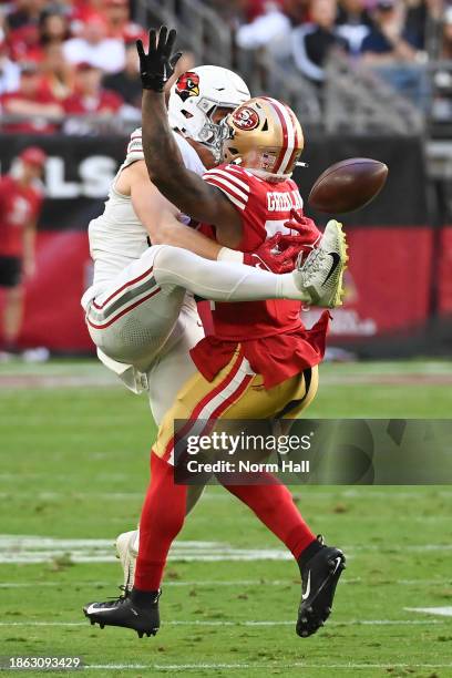 Trey McBride of the Arizona Cardinals attempts to make a catch around Dre Greenlaw of the San Francisco 49ers during the first quarter of a game at...