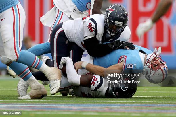 Desmond King II and Sheldon Rankins both of the Houston Texans sack Will Levis of the Tennessee Titans during overtime at Nissan Stadium on December...