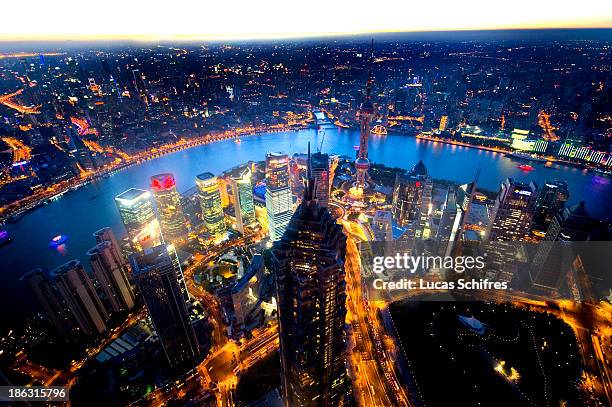 The Jinmao tower and the Pudong business district stand at dusk, with the Puxi district behind the Huangpu river, as taken from Shanghai World...