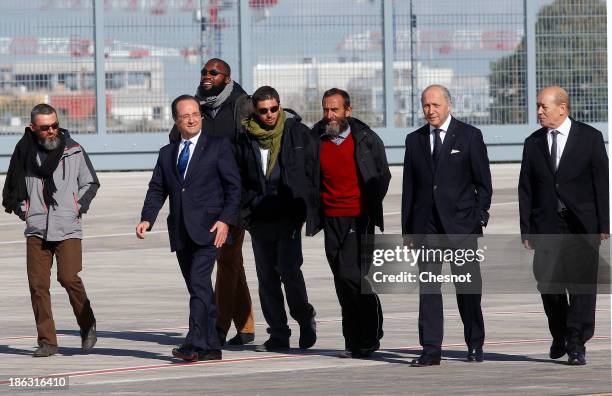 French president Francois Hollande , French Foreign Affairs Minister Laurent Fabius and Defence Minister Jean-Yves Le Drian welcome former French...