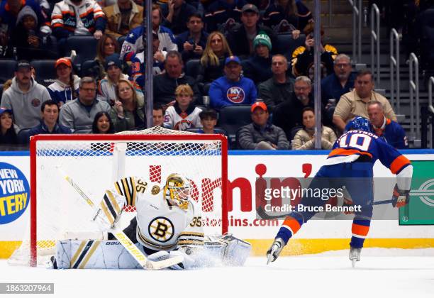 Simon Holmstrom of the New York Islanders roofs it against Linus Ullmark of the Boston Bruins during the shootout at UBS Arena on December 15, 2023...