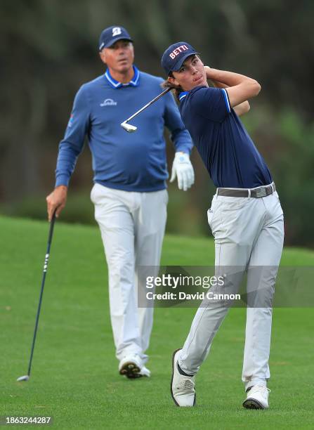 Cameron Kuchar of The United States plays his second shot on the 18th hole watched by his s father Matt Kuchar during the final round of the PNC...