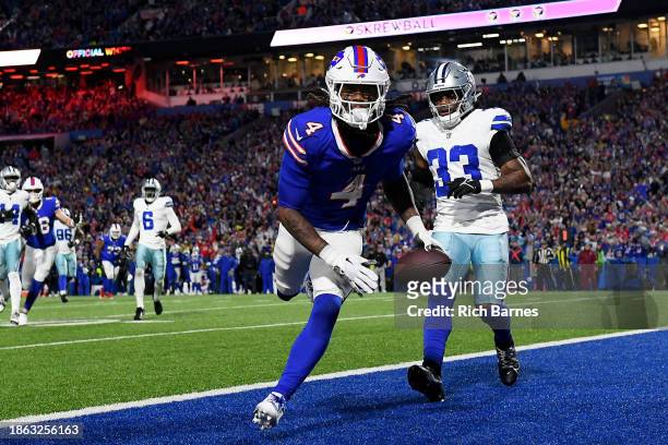 James Cook of the Buffalo Bills catches a touchdown pass in front of Damone Clark of the Dallas Cowboys during the second quarter at Highmark Stadium...