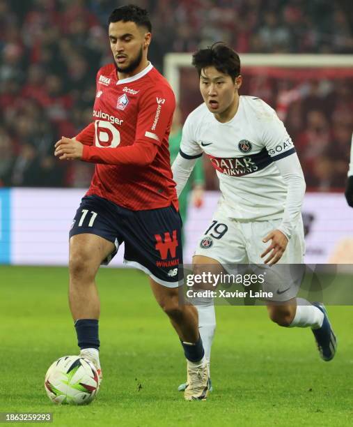 Lee Kang-In of Paris Saint-Germain in action with Adam Ounas of Lille during the Ligue 1 Uber Eats match between Lille OSC and Paris Saint-Germain at...