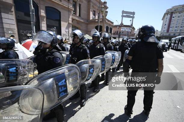 Members of the anti-riot police stand guard at the Constitucion square in Buenos Aires, on December 20, 2023. Argentina is commemorating these days...