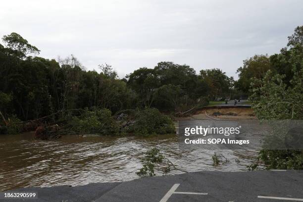An enormous section of road at the end of the Holloways Beach esplanade was washed away amid major flooding from high tide and the overflowing Barron...
