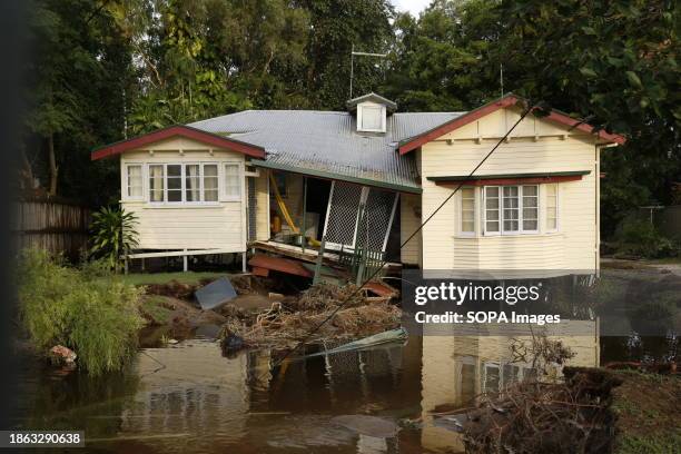 House and road has partially collapsed, bring down power lines and poles in the Cairns suburb of Holloways Beach after major flooding.