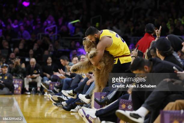 Los Angeles, CA Brodie The Goldendoodle gets help showing off for the TV cameras from caretaker Cliff Brush Jr.'s while enjoying courtside seats near...