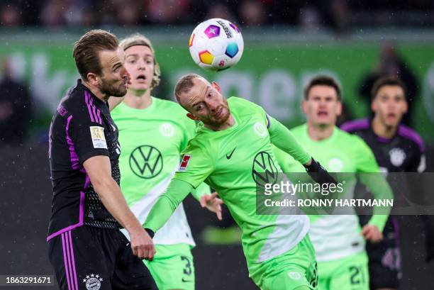 Bayern Munich's English forward Harry Kane and Wolfsburg's German midfielder Maximilian Arnold vie for the ball during the German first division...