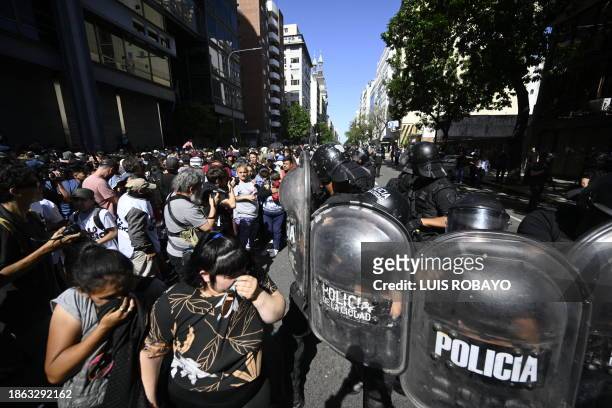 Riot police remove protesters from the roadway during the first demonstration against the new government of Javier Milei in Buenos Aires on December...