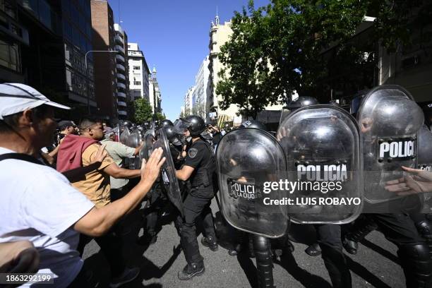 Riot police remove protesters from the roadway during the first demonstration against the new government of Javier Milei in Buenos Aires on December...