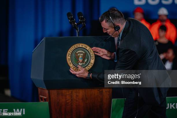 Worker attaches the presidential seal to a podium before US President Joe Biden speaks at an economic event at the Wisconsin Black Chamber of...