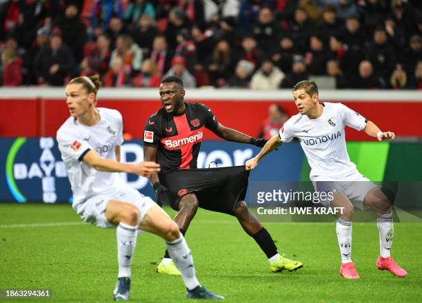 Bayer Leverkusen's Nigerian forward Victor Boniface and Bochum's Costa Rican defender Cristian Gamboa vie for the ball during the German first...