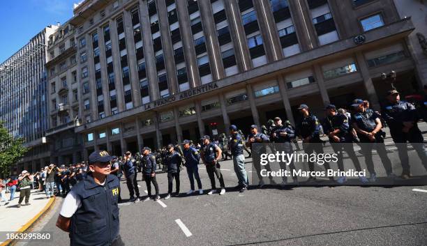 Police officers stand guard during a demonstration against President Javier Milei and recent announcements by Minister of Economy Luis Caputo on...