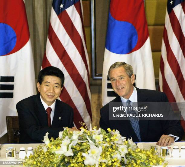 President George W. Bush and South Korean President Roh Moo-Hyun shake hands as they pose for the media at the start of their breakfast meeting,...