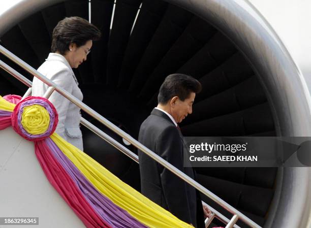 South Korean President Roh Moo-Hyun and his wife Kwon Yang-Sook leave the plane upon their arrival at the Royal Thai Air Force terminal in Bangkok,...