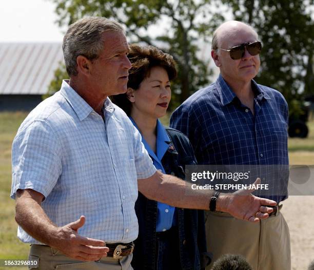 President George W. Bush talks to the media as Secretary of Treasury John Snow and Secretary of Labor Elaine Chao look on 13 August 2003 at Bush's...